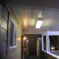 Covered upper-floor walkway with half wall and unit entries at the Lanai at the Cove in Seaside
