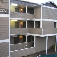 Three-story oceanfront condominium building in Seaside with open exit walkways on the second and third floors