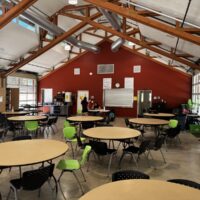 Inside the Camp Lutherwood dining hall, with exposed timber trusses and clerestory windows