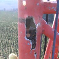 Hole rusted through a leg of the old guyed tower, seen during the climbing inspection