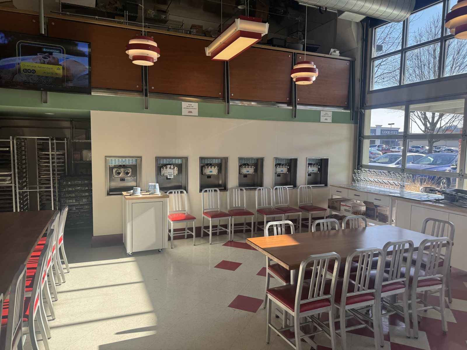 Restaurant dining room with a new cream wall holding a row of self-serve frozen yogurt dispensers