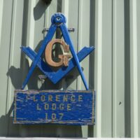 Masonic square-and-compass emblem and Florence Lodge 107 sign on the lodge wall