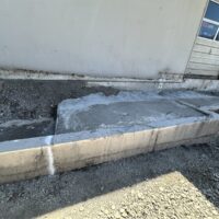 New concrete footing placed against an existing tilt-up wall for the storage addition