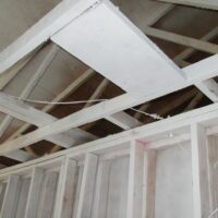 Opened wall and ceiling framing in a water-damaged senior apartment in Newport